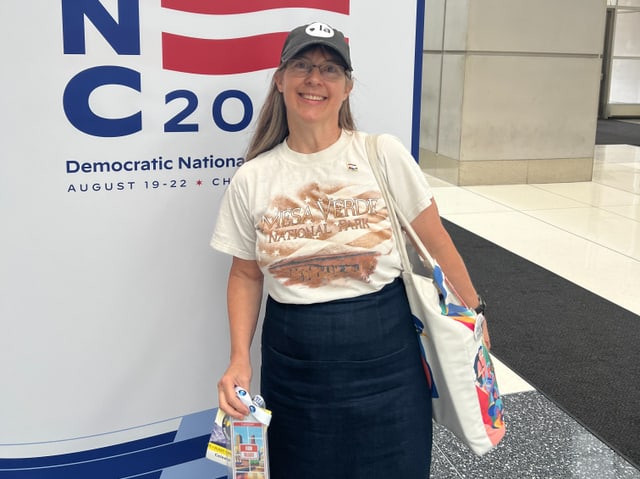 Frau steht vor einem Democratic National Convention 2020 Schild.