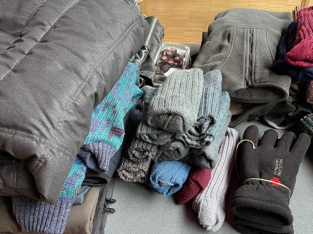 Jacken, Socken und Handschuhe auf einem Tisch