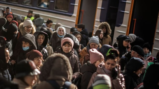 Flüchtende auf einem überfüllten Bahnsteig am Bahnhof