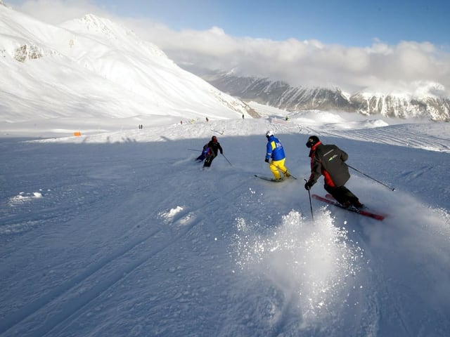 Skifahrer fahren hintereinander.