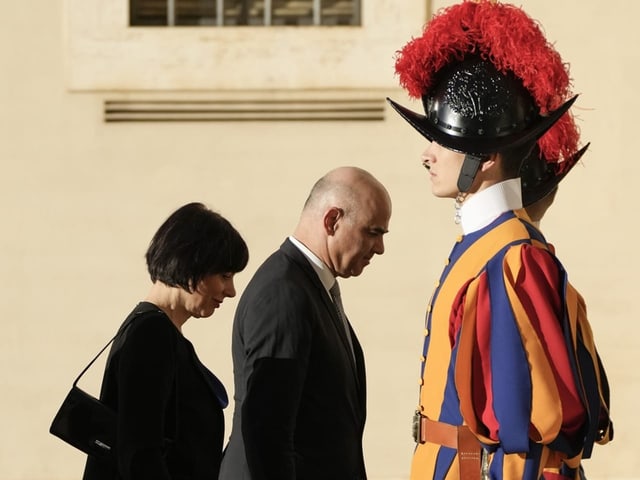 Bundesrat Alain Berset und seine Frau laufen an einer Schweizer Garde vorbei und blicken dabei auf den Boden.