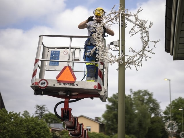 Ein Arbeiter installiert den Weihnachtsschmuck.