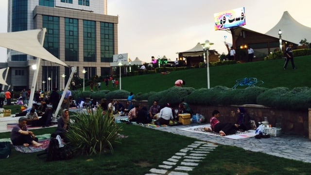 Menschen geniessen den Sommerabend in einem Park in Teheran.