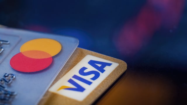 Eine Mastercard- und eine Visa-Karte aufeinandergelegt.