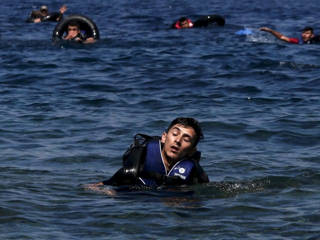 Ein Flüchtlinge im Meer schliesst vor Erschöpfung die Augen 