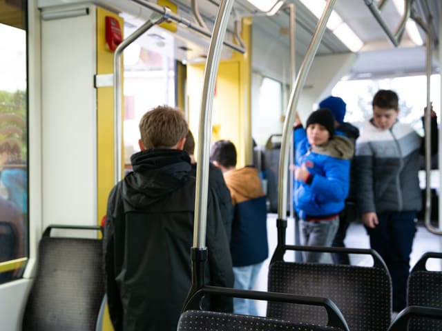 Ein paar Jungs drängen sich aus der Türe ins Freie.