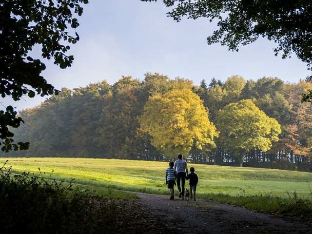 Mutter mit Kindern beim Spaziergang.