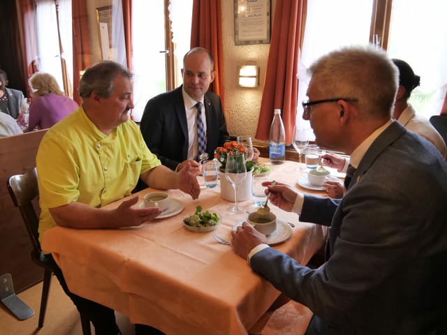 Ein Vierertisch. Die Runde isst Suppe und diskutiert.