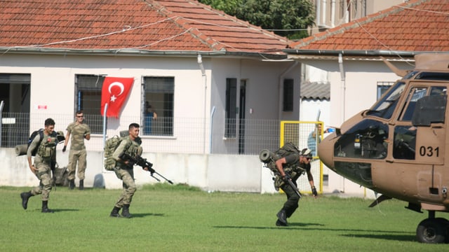 Soldaten laufen in geduckter Stellung zu einem Armeehelikopter