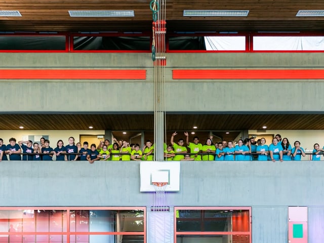 Kinder stehen auf einem Balkon in der Turnhalle