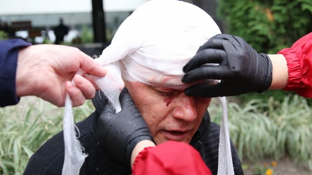 An injured protester receives improvised medical care.