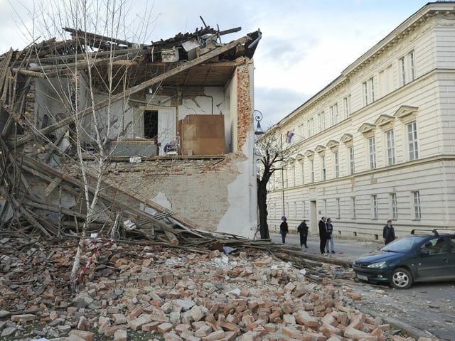 A house badly damaged, the rubble lies on the ground.