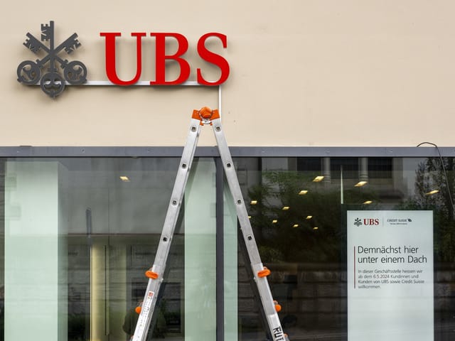 Leiter vor UBS-Logo an Gebäude.