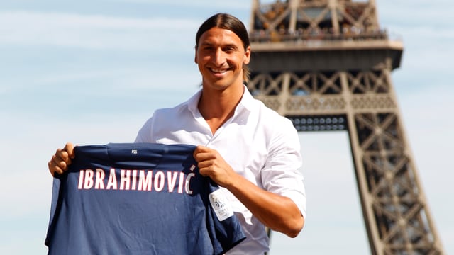 Zlatan Ibrahimovic bei seiner Verpflichtung für St. Germain vor dem Eiffelturm mit einem Trikot in den Händen.