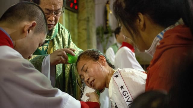 Chinese archbishop baptizes a believer