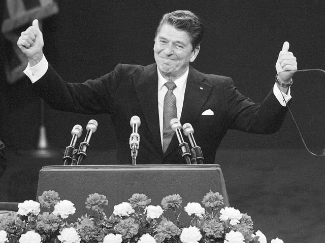 Reagan am Rednerpult - bei Daumen hebend.