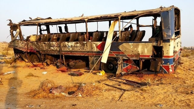 Ein total ausgebrannter Bus steht nach einem Bombenanschlag am Strassenrand.