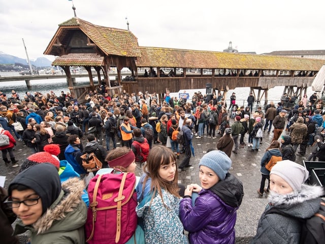 Kinder mit Schulthek vor der Kappellbrücke.