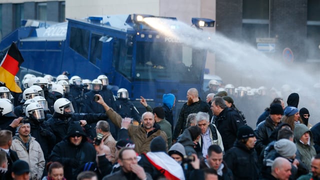 Ein Wasserwerfer der Polizei im Einsatz gegen Pegida-Demonstranten