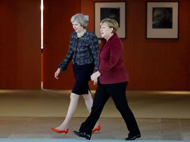 Zu sehen sind die beiden Regierungschefs Angela Merkel sowie Theresa May.