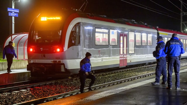 Polizeibeamte stehen auf Perron.