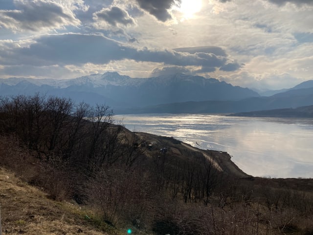 Ein See, ein Hügel und viele Wolken