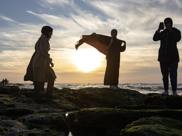 Drei Mädchen am Meer vor dem Sonnenuntergang