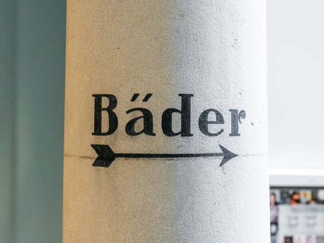 Auf einer Säule steht «Bäder», ein Pfeil zeigt nach rechts.