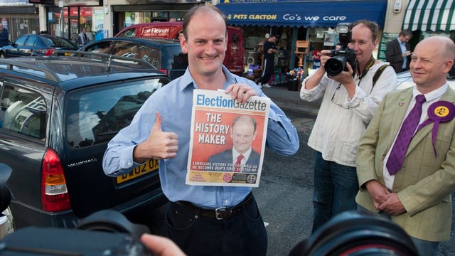 Douglas Carswell hält eine Zeitung in der Hand und streckt den Daumen hoch