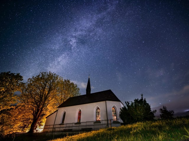 Kirche unter sternenklarem Nachthimmel.