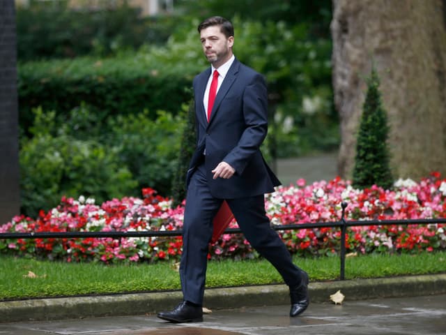 Stephen Crabb, ein Trottoir entlang gehend.