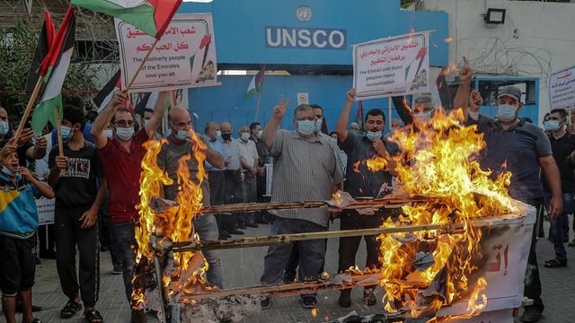 Protesters set fire to a banner