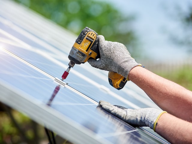 Installation eines Solarpanels mit einer Bohrmaschine.