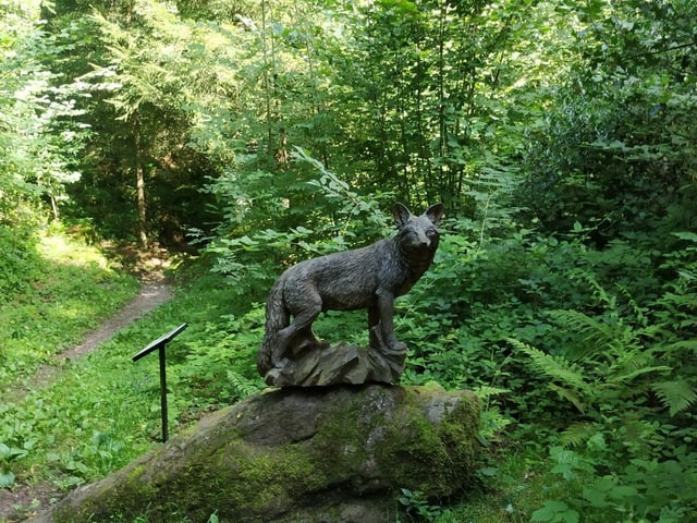 Wolf, geschnitzt aus Holz im Wald.