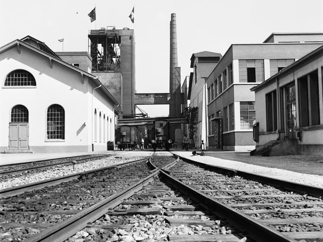 Schwarzweissfoto Bahngleise führen zu Gaswerk