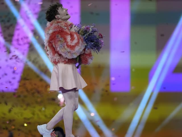 Nemo steht mit einem Blumenstrauss auf der ESC-Bühne