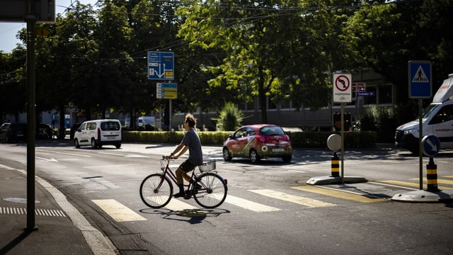 Mensch auf Velo auf einer Strasse.