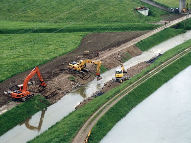 Überflutete Felder und Bagger an der Arbeit.