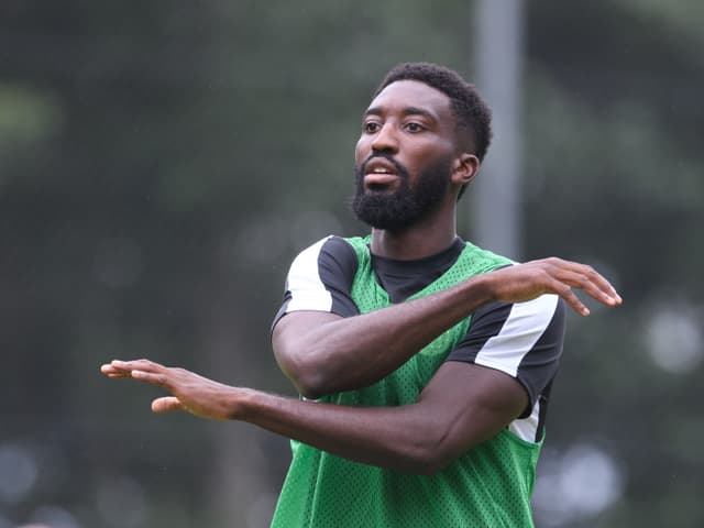 Fussballspieler im grünen Trainingsleibchen gestikuliert beim Training.