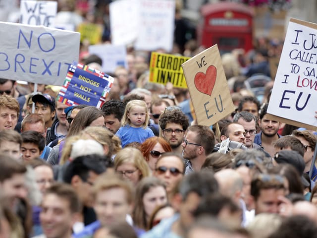 Hunderte von Demonstranten mit Transparenten.