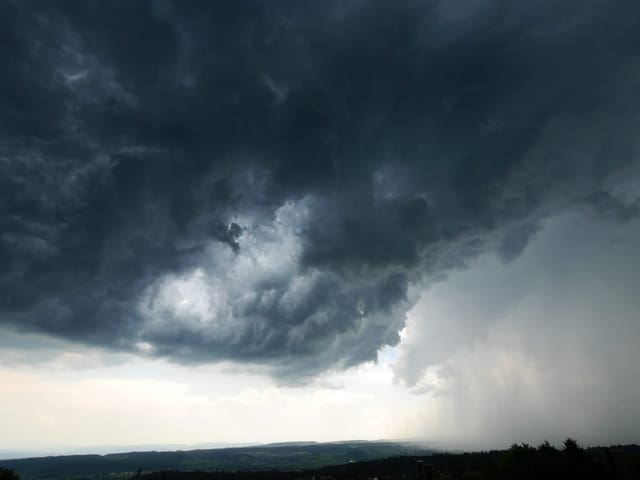 Dunkle Sturmwolken über einer Landschaft.