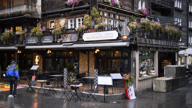 Ein Polizist steht vor dem Restaurant Walliserkanne in Zermatt.