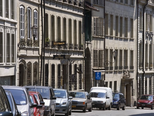 Eine Strasse mit parkierten Autos.