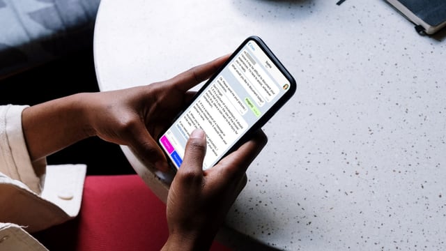 eine Frau hält ein Handy in der Hand und schreibt Nachrichten