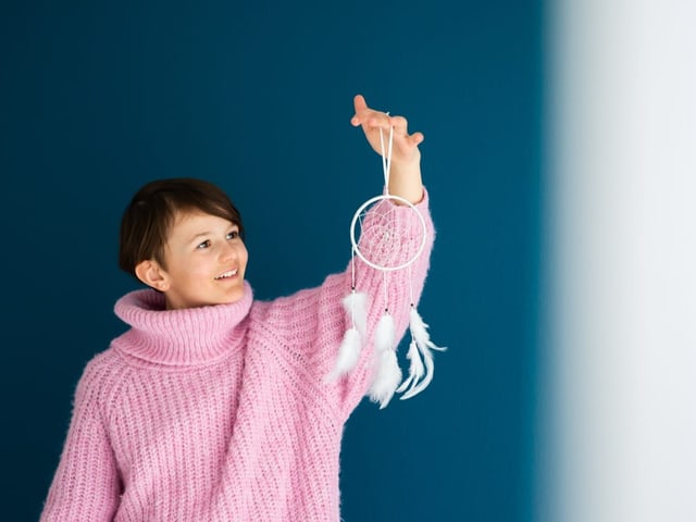 Anouk hält einen Traumfänger in der Hand.