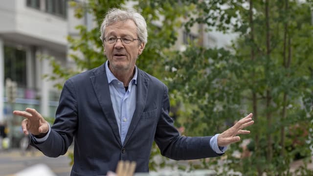 Ein Mann mit grauem Haar, Brille und Sakko.