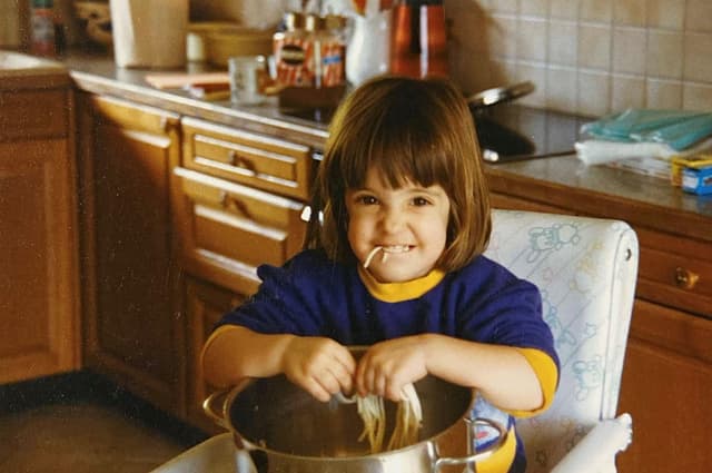 Klein Céline isst Spaghetti direkt aus dem Topf.