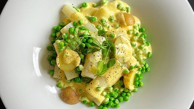 Gemüsesalat aus weissem Spargel. Kartoffeln und Erbsen an Sauce Hollandaise. 