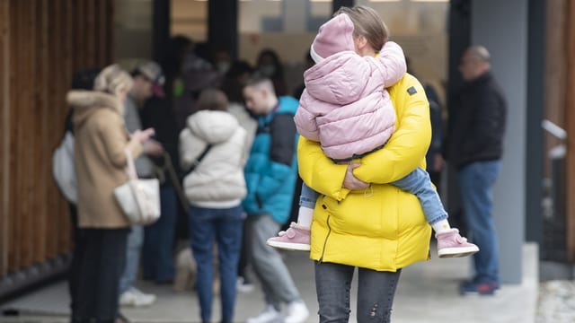 Frau hält Kind auf dem Arm