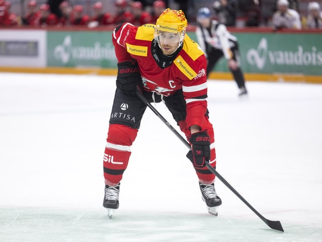 Eishockeyspieler in rotem Trikot auf dem Eis.